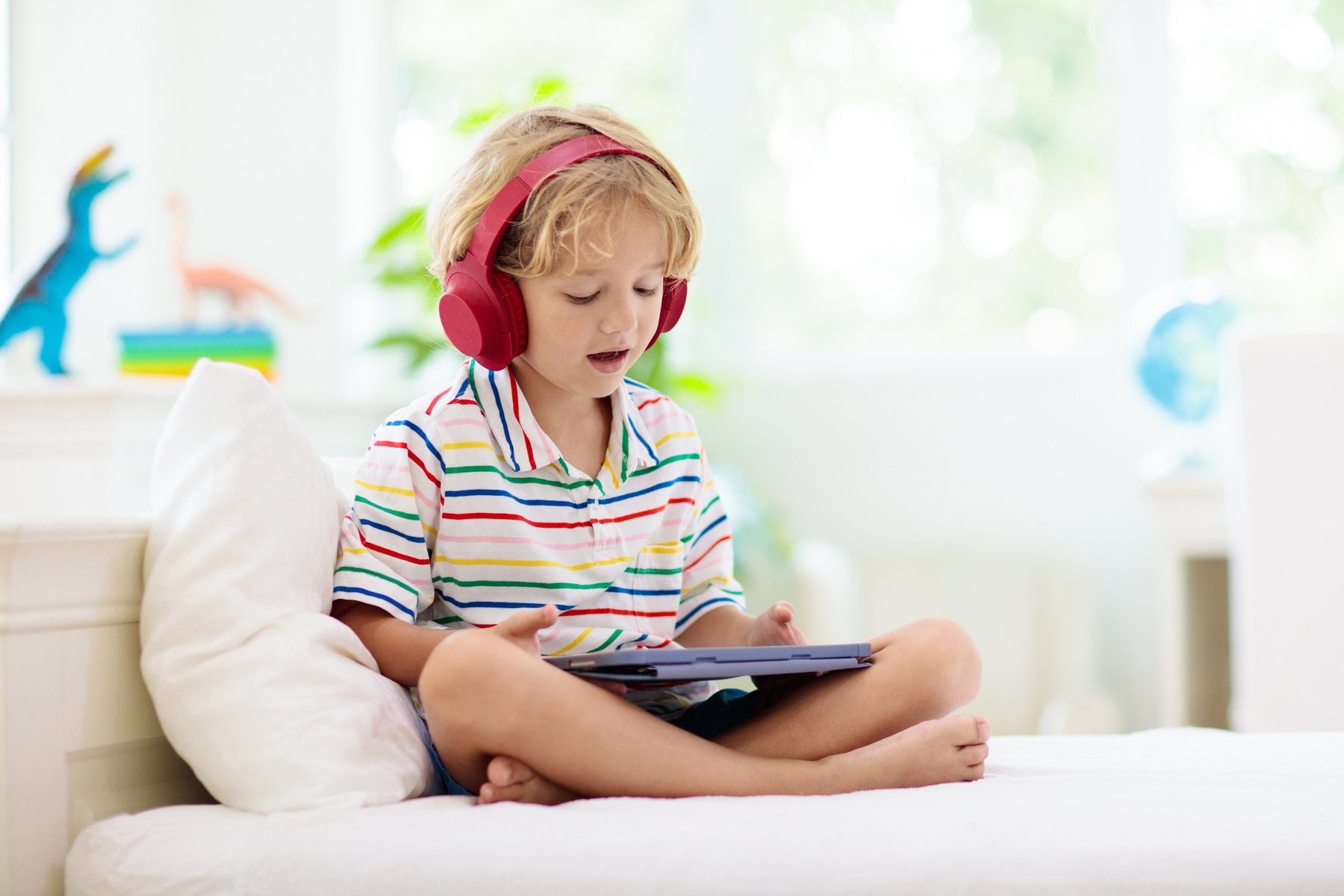 Child with tablet computer. Kids study online.